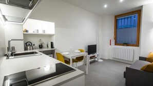 A compact kitchen with a dining area, a TV, and a window with a view. - Italianway - Del Sale 4 (Udine)