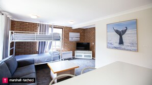 A bunk room with a TV, a painting of a whale, and a view of the sea. - George Hideaway - George St 30A (Bermagui)