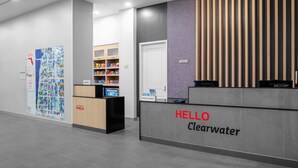 A reception desk with a 'HELLO Clearwater' sign, a map display, and a minibar area. - Towneplace Suites By Marriott Tampa Clearwater (Clearwater)