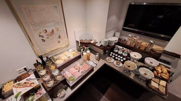 A buffet setup with various food items and condiments.