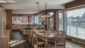 A spacious dining area with a large table set for six, surrounded by wooden chairs with cushioned seats. - Marble Canyon 3 Bdrm|Sleeps 8 (12 inc kids): Unit 102P1 (Fairmont Hot Springs)