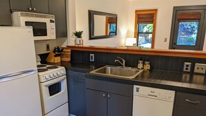A compact kitchen with a stove, microwave, sink, and dishwasher. - Bluebird Day - River Otter, Charming 1BR duplex in Old Downtown Bend (Bend)