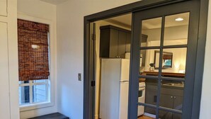 A compact kitchen with a refrigerator, a stove, and cabinets. - Bluebird Day - River Otter, Charming 1BR duplex in Old Downtown Bend (Bend)