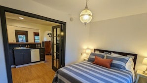 A bedroom with a bed, bedside tables, and a chandelier. - Bluebird Day - River Otter, Charming 1BR duplex in Old Downtown Bend (Bend)