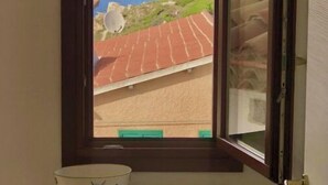 Una ventana con vistas al mar y un edificio de techo rojo.