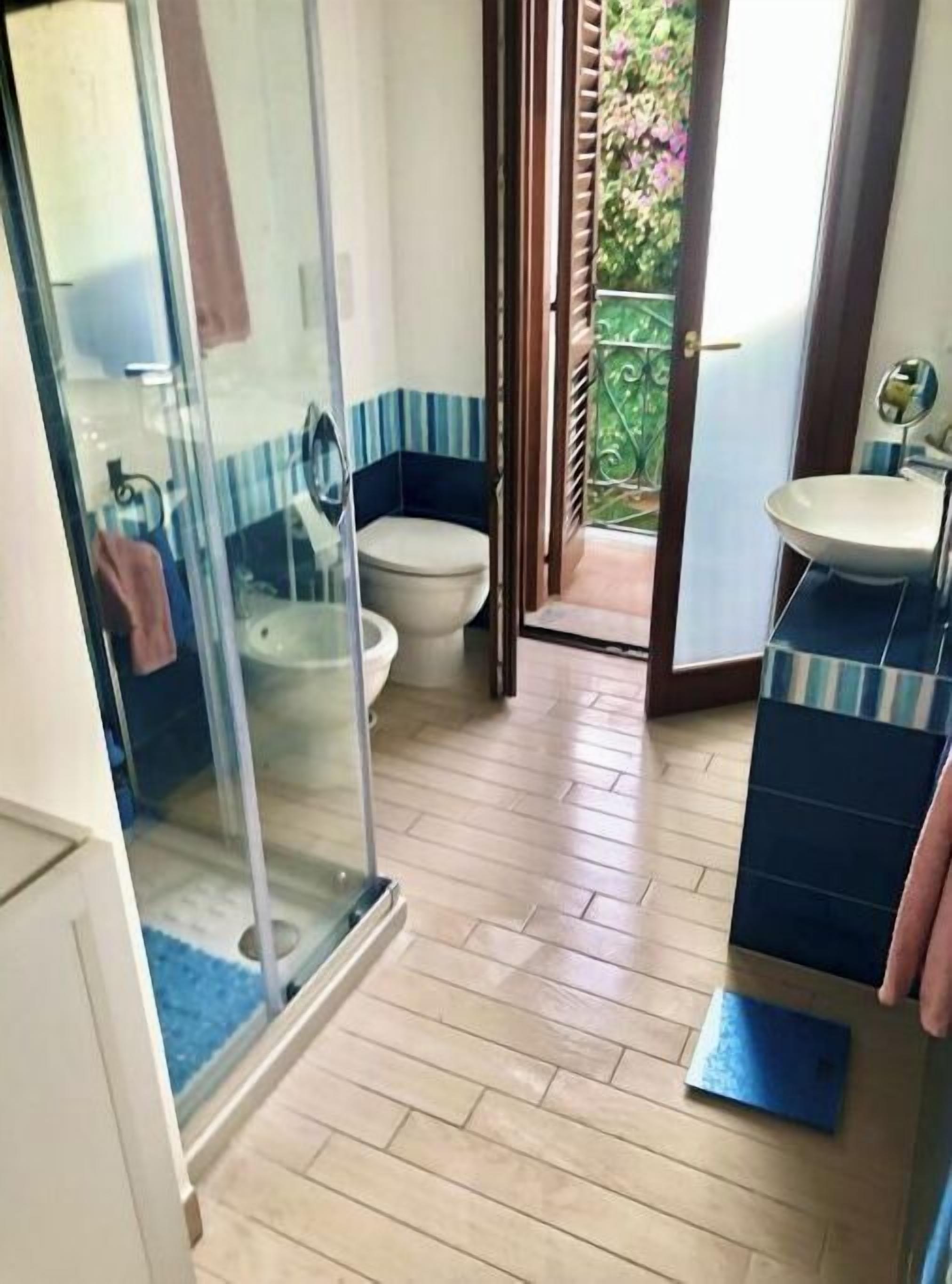 Une salle de bain avec une douche à parois de verre, des toilettes et un lavabo.