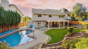 A two-story house with a backyard featuring a swimming pool, a patio with outdoor furniture, and a well-maintained lawn. - @ Marbella Lane - 4BR SiliconValley Gem|Pool House (San Jose)