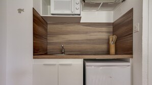 A compact kitchen with a microwave, a sink, and a dishwasher. - Le Loriot - One Bedroom Apartment, Sleeps 4 (Saint-Nic)