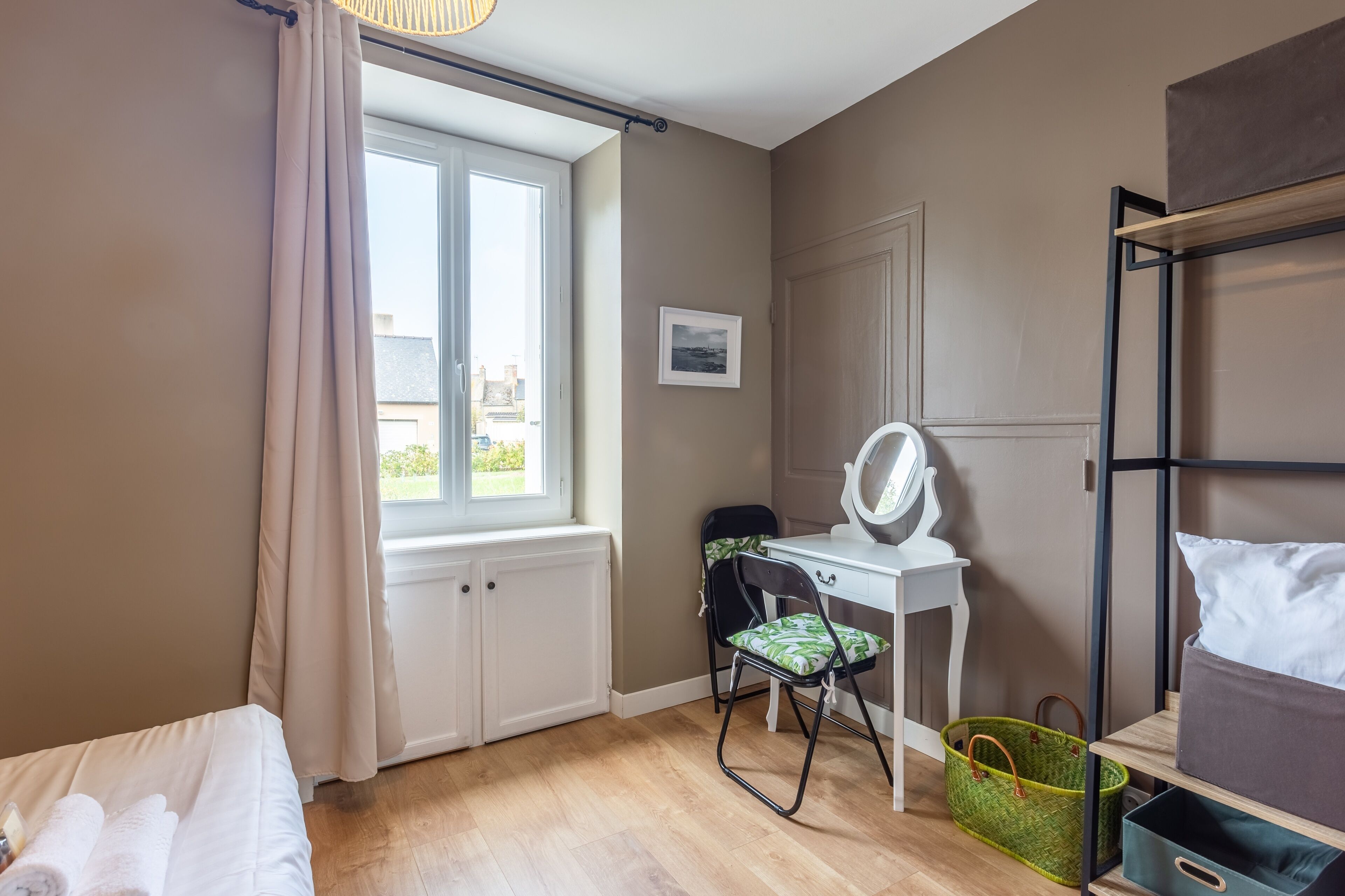 Une chambre à coucher avec un lit, un bureau et une chaise, une fenêtre et un lit superposé.