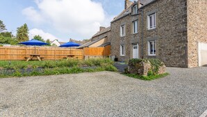 A stone building with a gravel driveway and a wooden fence. - Rochebonne - One Bedroom Apartment, Sleeps 4 (Saint-Coulomb)