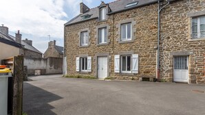 A stone building with multiple windows and doors, a paved driveway, and a small garden area. - Rochebonne - One Bedroom Apartment, Sleeps 4 (Saint-Coulomb)