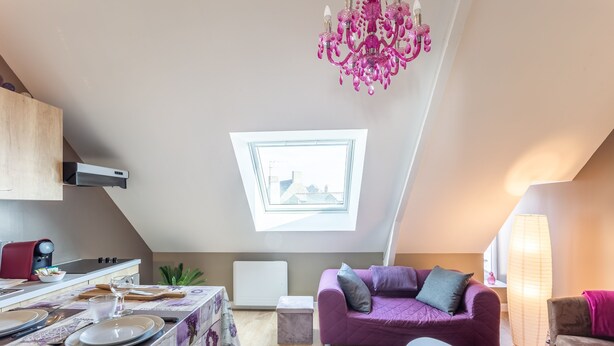 A modern loft apartment with a dining area, a purple sofa, and a chandelier. - Chevrets - One Bedroom Apartment, Sleeps 2 (Saint-Coulomb)
