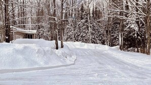 Eine verschneite Landschaft, auf der ein Haus teilweise im Schnee verborgen ist.
