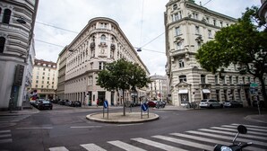 A street view with a roundabout, historic buildings, and parked cars. - Pension Central - Self Check-in (Vienna)
