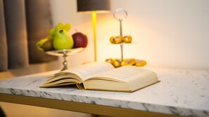 An open book on a marble table with fruits in the background. - Pension Central - Self Check-in (Vienna)