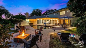 A backyard with a fire pit, outdoor seating, and a pool area. - 8BR Villa with Heated Pool Near Beach (Largo)