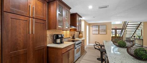 A modern kitchen with wooden cabinets, a granite countertop, and a built-in oven.