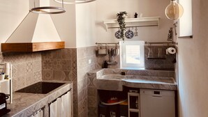 A modern kitchen with a built-in oven, a stainless steel sink, and a hanging light fixture. - Camogli Eden Luxury - spacious and cozy apartment by the sea (Camogli)