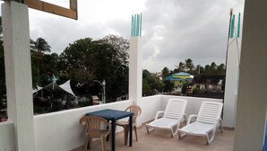 A balcony with a table and chairs, a view of the neighborhood, and a clear sky. - San San Andrés Magic House 0 by BBBSAI (San Andrés)