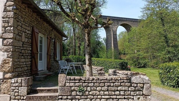 A stone building with a brick bridge in the background.