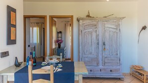Un comedor con una mesa lista para dos personas, un aparador de madera rústica y una lámpara en el techo.