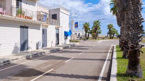 A street with buildings, a palm tree, and a clear sky. - Holiday Apartment Fico D'India with Sea View, Terrace & Wi-Fi (San Cataldo)