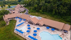 An aerial view of a resort with a large swimming pool, sun loungers, and a covered patio area. - Fall beauty! Hot tub, Family Friendly, Games Firepit, Pool/Marina Access (Galena)