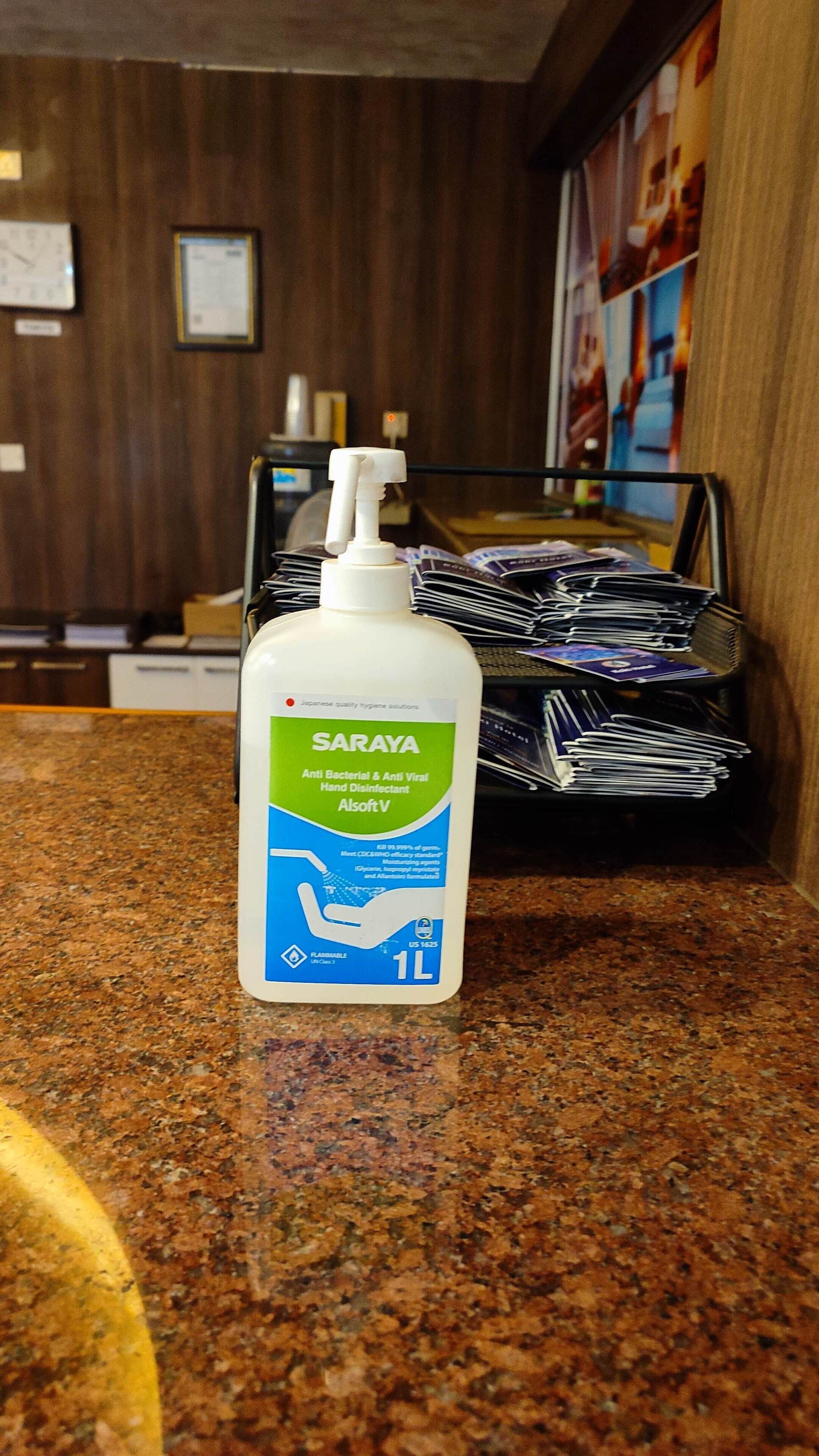 A bottle of Saraya Anti Bacterial & Anti Viral Hand Disinfectant on a granite countertop.