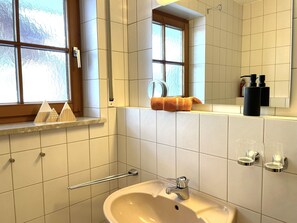 A bathroom with a sink, mirror, towel rack, and window. - Country house Obermaiselstein THE VIEW - wonderful mountain view from apartment Besler (Obermaiselstein)