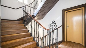 A wooden staircase with a metal railing and a wooden door at the top.
