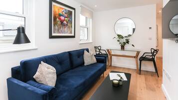 Departamento urbano, baño privado | Área de sala de estar