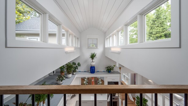 Ein großzügiger Innenraum mit hohen Decken, großen Fenstern und einer zentralen Treppe.
