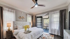 A bedroom with a large bed, a ceiling fan, and a view to the outside. - A charming and welcoming space filled with natural light, comfortable furnishings, and a calm atmosphere for an easy stay. (Dallas)