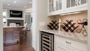 A kitchen with white cabinets, a wine cooler, and a built-in oven. - MINNeSTAY* Dean Parkway Estate Luxury | Spacious (Minneapolis)