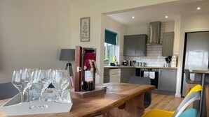 A modern kitchen with grey cabinets, a stainless steel range hood, and a built-in oven. - Luxury 5-bed House With Tennis Court & Games Room (Steyning)
