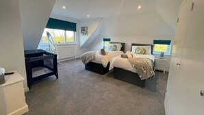 A bedroom with two beds, a desk, and a window. - Luxury 5-bed House With Tennis Court & Games Room (Steyning)