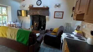 Una sala de estar con chimenea, un comedor y una cocina.