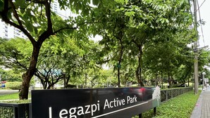 Segnaletica per il parco Legazpi Active con un percorso pedonale lastricato e vegetazione.