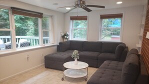 A living room with a grey sectional sofa, a white coffee table with a vase, and a ceiling fan. - Amazing Escape - 4 BEDS, 3 BEDROOMS, Private Deck near DC (Annandale)
