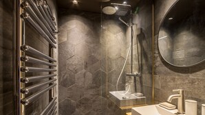 Une salle de bain moderne avec une douche en verre, un grand miroir et un meuble-lavabo en bois.