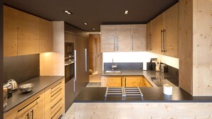 Une cuisine moderne avec des meubles en bois, un évier en acier inoxydable et un plan de travail noir.