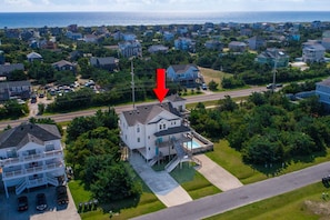 Um bairro residencial com uma casa destacada, com uma varanda grande e piscina.