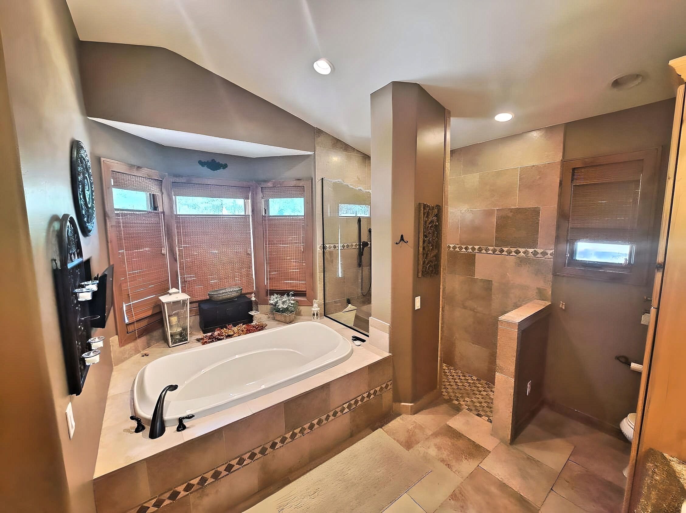 Une salle de bain spacieuse dotée d’une grande baignoire, d’une douche à l’italienne et d’un meuble-lavabo avec un miroir.