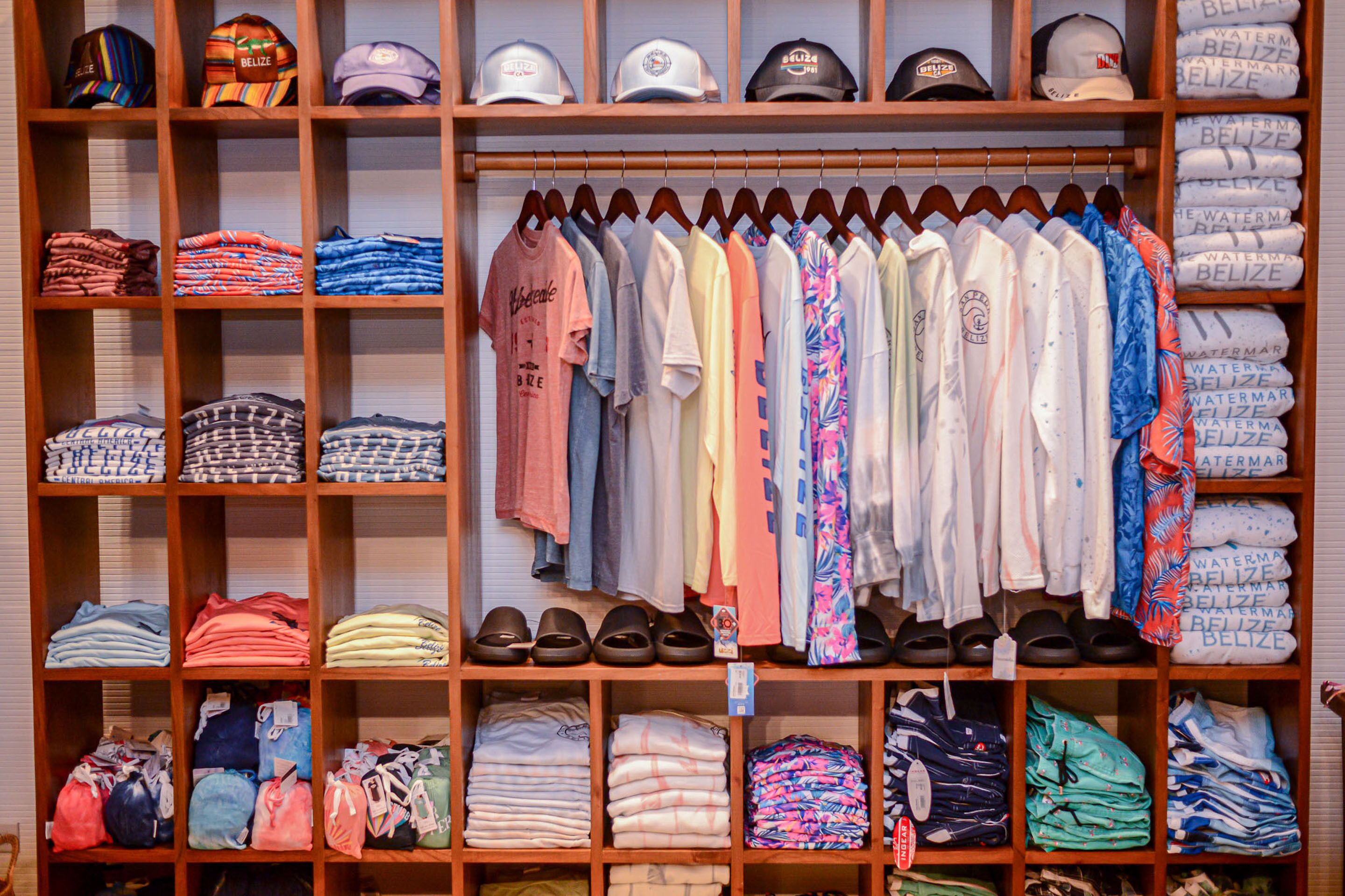 A clothing store with neatly organized shelves and racks of various apparel and accessories.