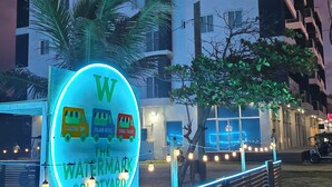 A sign for 'The Waterfront Courtyard' with a neon outline of a water taxi, island bites, and a final touch. - The Watermark Hotel (San Pedro)