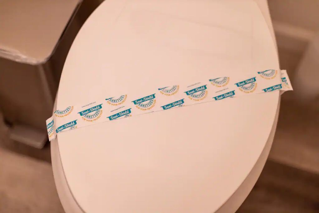 Eine Toilettensitze mit einem angebauten Papierhandtuchspender.