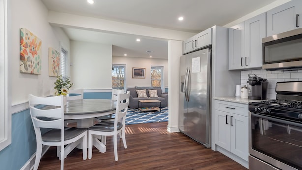 A modern kitchen with grey cabinets, a stainless steel refrigerator, and a black stove. - Beautiful Renovated Townhome w/parking (Holden)