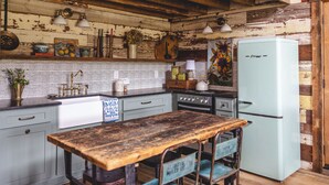 Una cucina rustica con pareti in legno, un frigorifero d'epoca e un tavolo di legno.