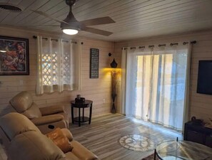 Relax in this spacious living room with a sofa set, coffee table, and large window.