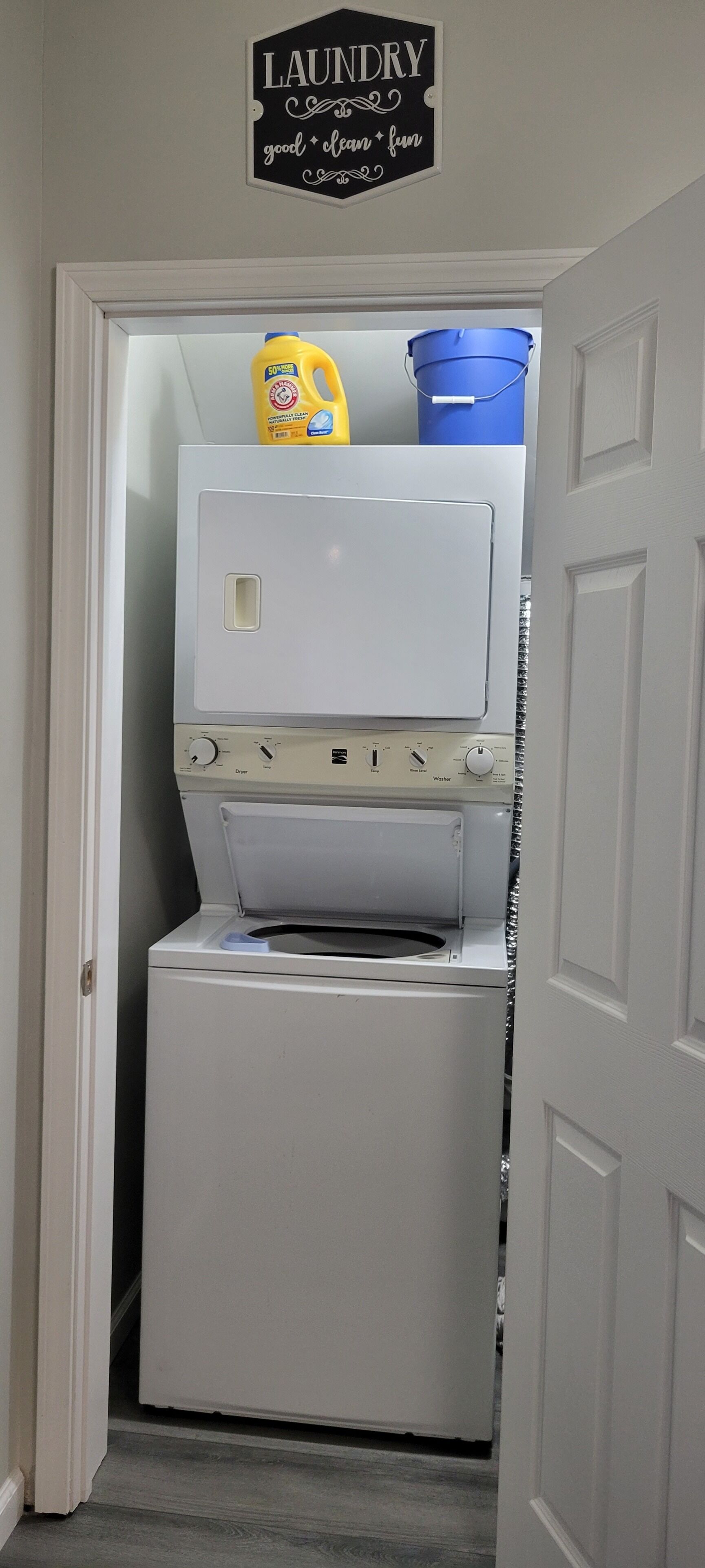 A laundry room with a washing machine, a dryer, and a laundry detergent bottle.